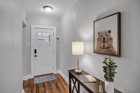 Welcoming entry with rustic decor, cozy rug, and modern lighting.