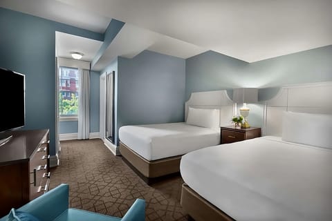 Unwind in bright double-queen comfort with city-window views.