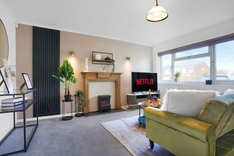 A spacious living room with a comfortable corner sofa and a large 50’’ Smart TV with Netflix subscription included