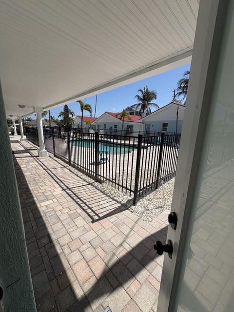 Bedroom 2 with back door to courtyard with pool view