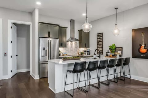White kitchen island with seating for six in sleek black chairs.