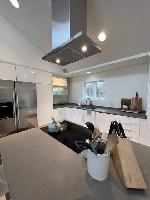 Kitchen island seats 5 and includes cooktop.