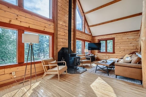 Welcome to our spacious Mountain Cabin in the majestic Rocky Mountains! Our living space features angle-top windows that offer panoramic views of the stunning surroundings. 