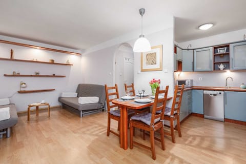 A cozy dining and living area with a wooden table, chairs, and a comfortable sofa.
