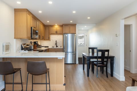 The eat-in kitchen offers a dining table for two and a breakfast bar with seats two more.