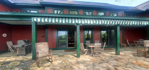 Covered back patio with outdoor seating and a view toward the pond.