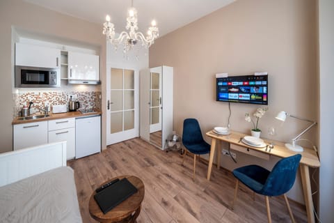 Living bedroom with kitchenette, double bed, work desk and wardrobe