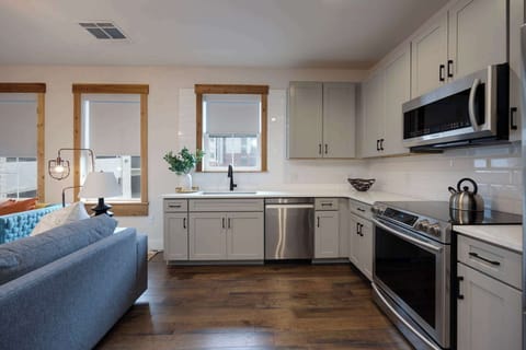 Embrace a unique design aesthetic by incorporating a blue couch into your kitchen decor. The combination of sleek furniture with classic hardwood floors adds a touch of sophistication to the space.