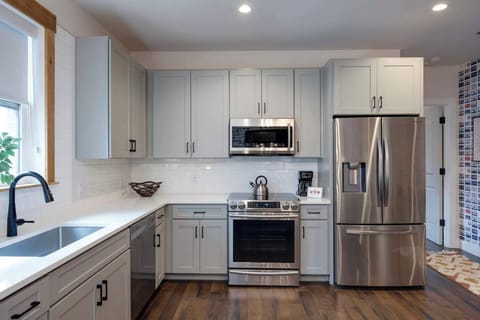 Clean and modern kitchen featuring stainless steel appliances and warm wood floors for a stylish and functional look.