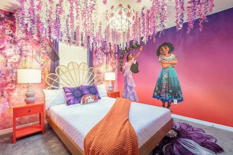 Enchanting themed bedroom inspired by a magical family, featuring vibrant wall art, a stunning chandelier, floral ceiling decor, and cozy bedding. A whimsical retreat perfect for sparking imagination and creating unforgettable memories