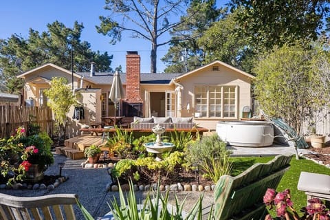 3 sets of french doors lead to a large sunny backyard with a hot tub,  outdoor shower, fireplace, and garden. Fully fenced.