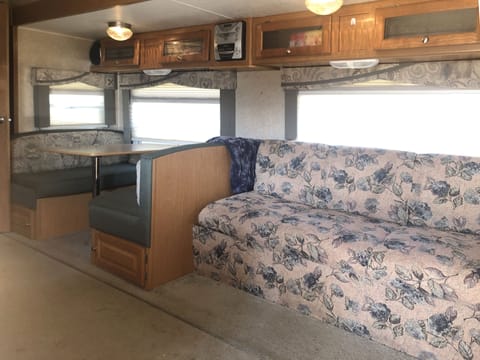 Inside RV, sofa and dining area.