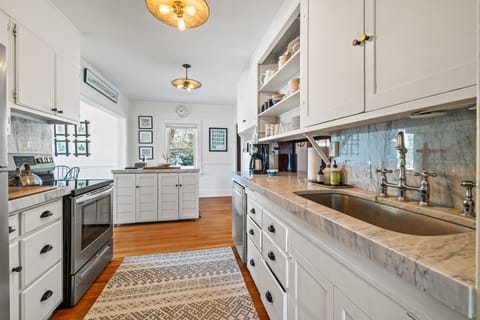 Kitchen is fully stocked with utensils, plenty of glassware and cookware.