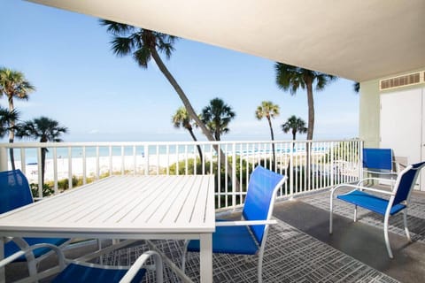 Ocean-view balcony w/ blue seating, palm-lined scenery, & space to unwind outdoors.