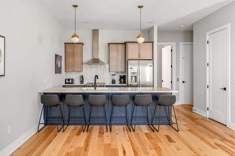 Stylish kitchen featuring stainless steel appliances, a 6-seat island, and rich blue and brown tones.