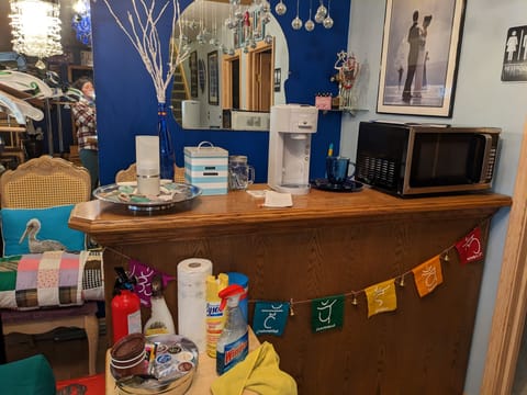 Microwave, coffee maker, plastic utensils, coffee pods, tea, sugar, paper towels