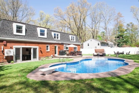 The Saratgoa Oasis.  Your pool house with a full bar and game room opens up to this beautiful backyard equipped with a jacuzzi, day bed, fire pit, dining table and babrbeque.