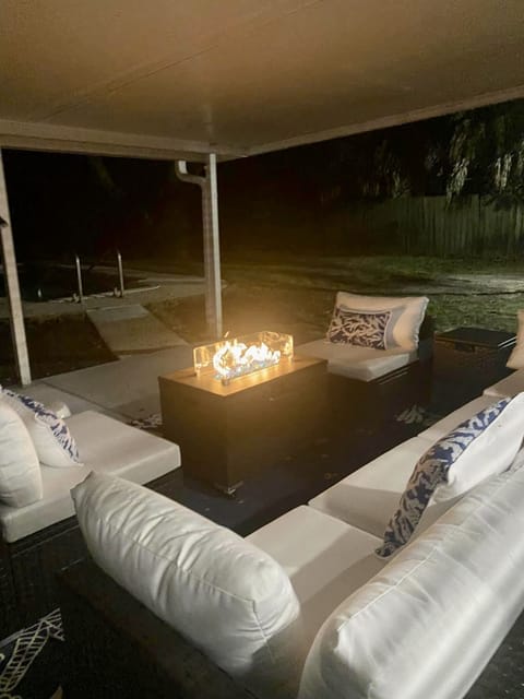 Fire pit at night on the outdoor patio with gas grill.
