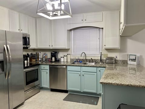 Fully stocked kitchen with modern cooking utensils and appliances.
