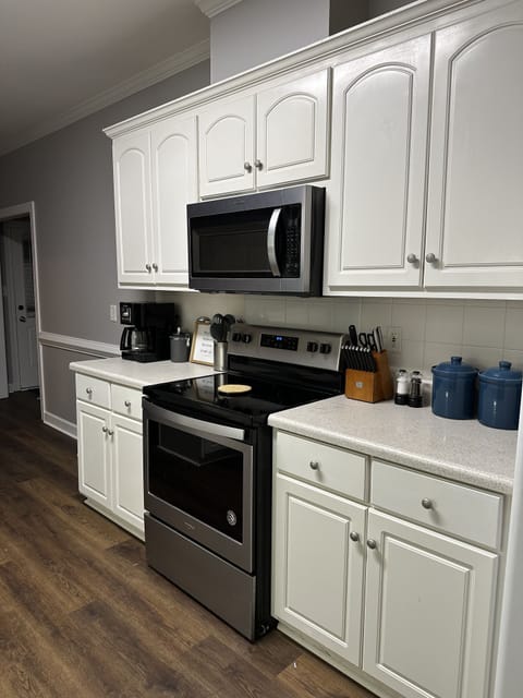 Galley style kitchen with a stove, dish washer, refrigerator, and microwave