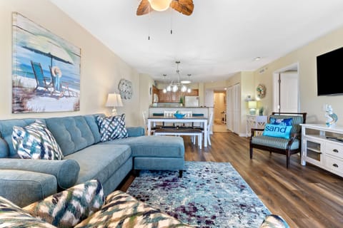 Relax in your coastal-themed living space with plush blue seating, beach artwork, and open layout perfect for unwinding after seaside adventures.