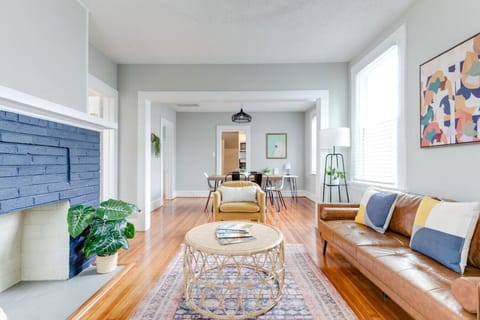 Bright and inviting living room with Smart TV, board games, and a cozy leather sofa. Decorative fireplace and modern lighting create the perfect spot to relax, with easy flow into the dining area.
