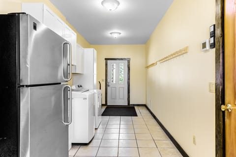 Entryway with washer, dryer, sink, and extra full fridge.