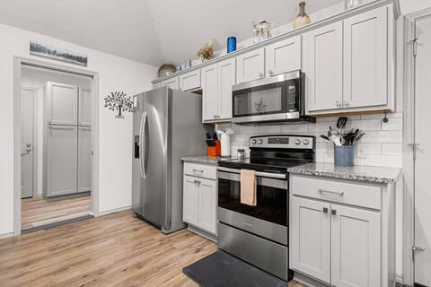 Cool gray cabinets, granite countertops, stainless-steel appliances, and full-sized pantry make for a chef's dream.