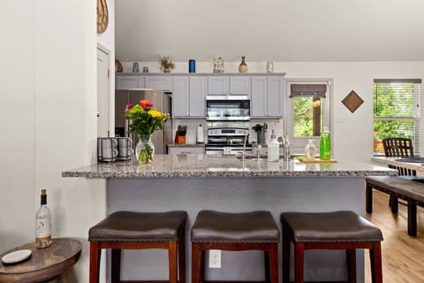 Open concept living, dining, and kitchen area with additional barstool seating means everyone remains part of the conversation.