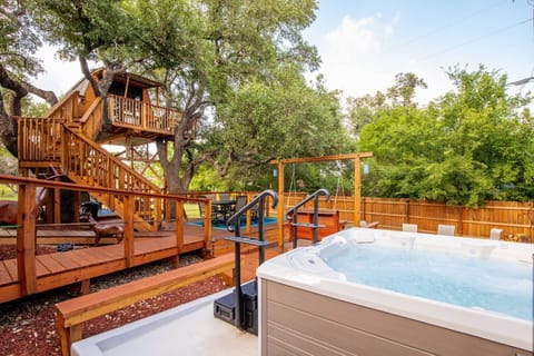 Embrace the enchanting ambiance of an outdoor oasis, complete with a bubbling hot tub and a charming fire pit seating area, ideal for cozy gatherings.