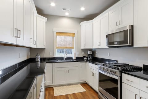 Fully equipped kitchen with gas stove, refrigerator, microwave, dishwasher.