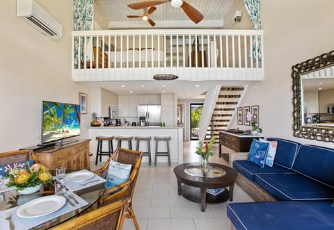 Lofty island living awaits with breezy rattan charm, ocean-blue accents, and a modern kitchen that shines bright    