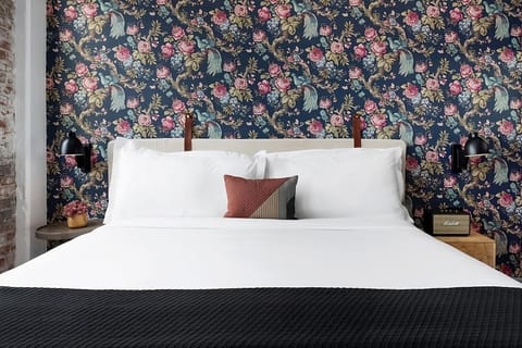 Sink into cloud-soft pillows against dramatic floral wallpaper.