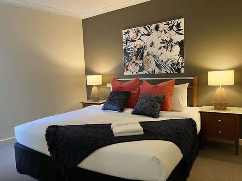 Rest easy in our master bedroom! Sink into a comfortable bed, piled high with soft pillows and a cozy blanket. Convenient bedside tables with drawer storage and warm lamps flank the bed, while fresh towels are readily available for your comfort.