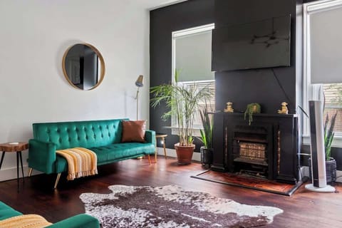 Discover the Charm of Our Jungle House Airbnb - Stylish Living Room with Modern Decor! Round Mirror & Gold Accents ️