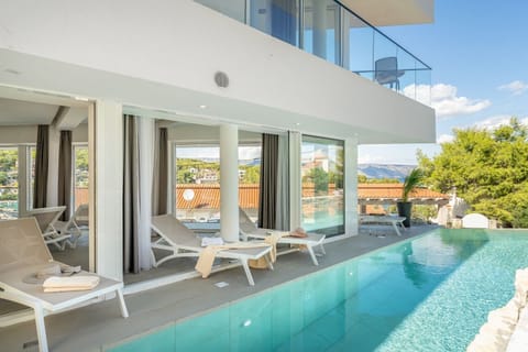 View of the outdoor terrace with deckchairs by the pool in Croatia luxury villa Ideali in Vrboska