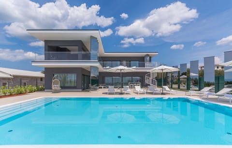 Private swimming pool surrounded by deckchairs for sunbathing in the luxury villa Nimai Luce in Istria