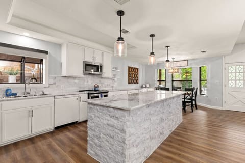 Spacious, fully equipped kitchen with stainless steel appliances, ample counter space, and a large island—ideal for cooking together or gathering with drinks and snacks.