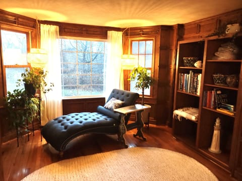 Take advantage of the library. Relax with a book and admire the wooded backyard.