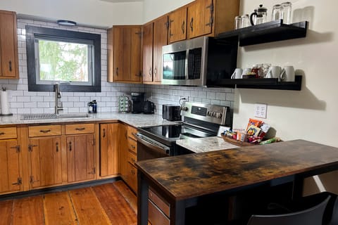 The fully stocked kitchen has granite countertops & stainless steel appliances