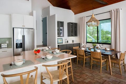 Kitchen opens to dining area and wet bar with a view towards to the back patio