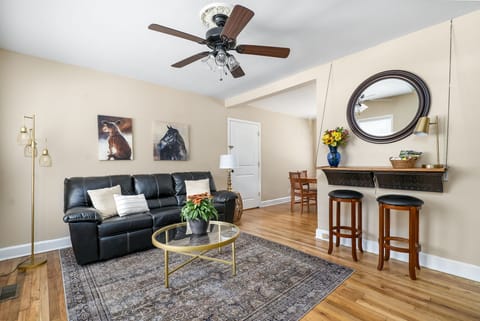 The living room is full of light and features a Roku TV and electric fireplace.