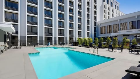Dive into a sparkling pool surrounded by sunny lounge space.