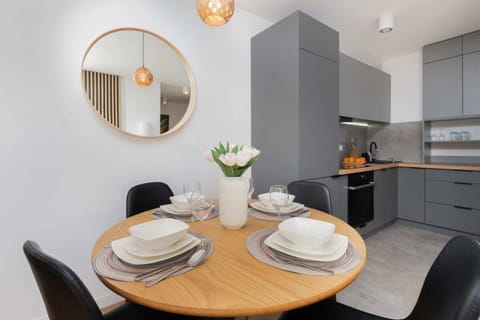 A round dining table set for four, with a modern and elegant design in a bright kitchen corner.
