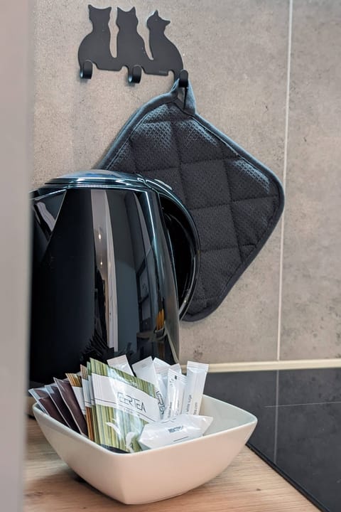 A close-up of a kitchen detail featuring hooks with utensils and a small organized counter space.
