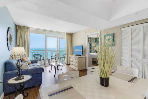 Enjoy breathtaking ocean views from this open and airy living and dining area. Relax on the plush sofa, dine in style, or step onto the private balcony for a perfect beachside retreat. 