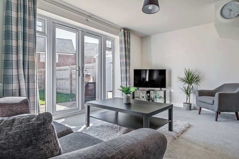 A welcoming lounge featuring a large sofa, Smart TV, and a dining table for 4, ideal for both relaxation and meals