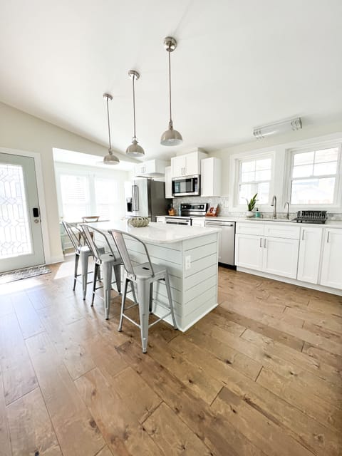 Fully stocked kitchen with desk and chair, kids table and chairs, and island 