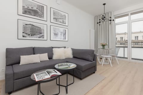 A cozy living room with a modern gray sofa, a glass coffee table, and stylish wall art.
