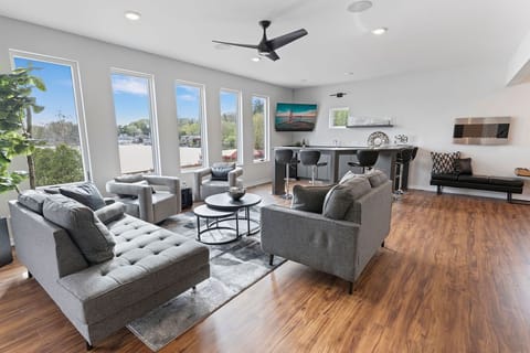 Main floor living room/bar area with amazing floor to ceiling lake views! 